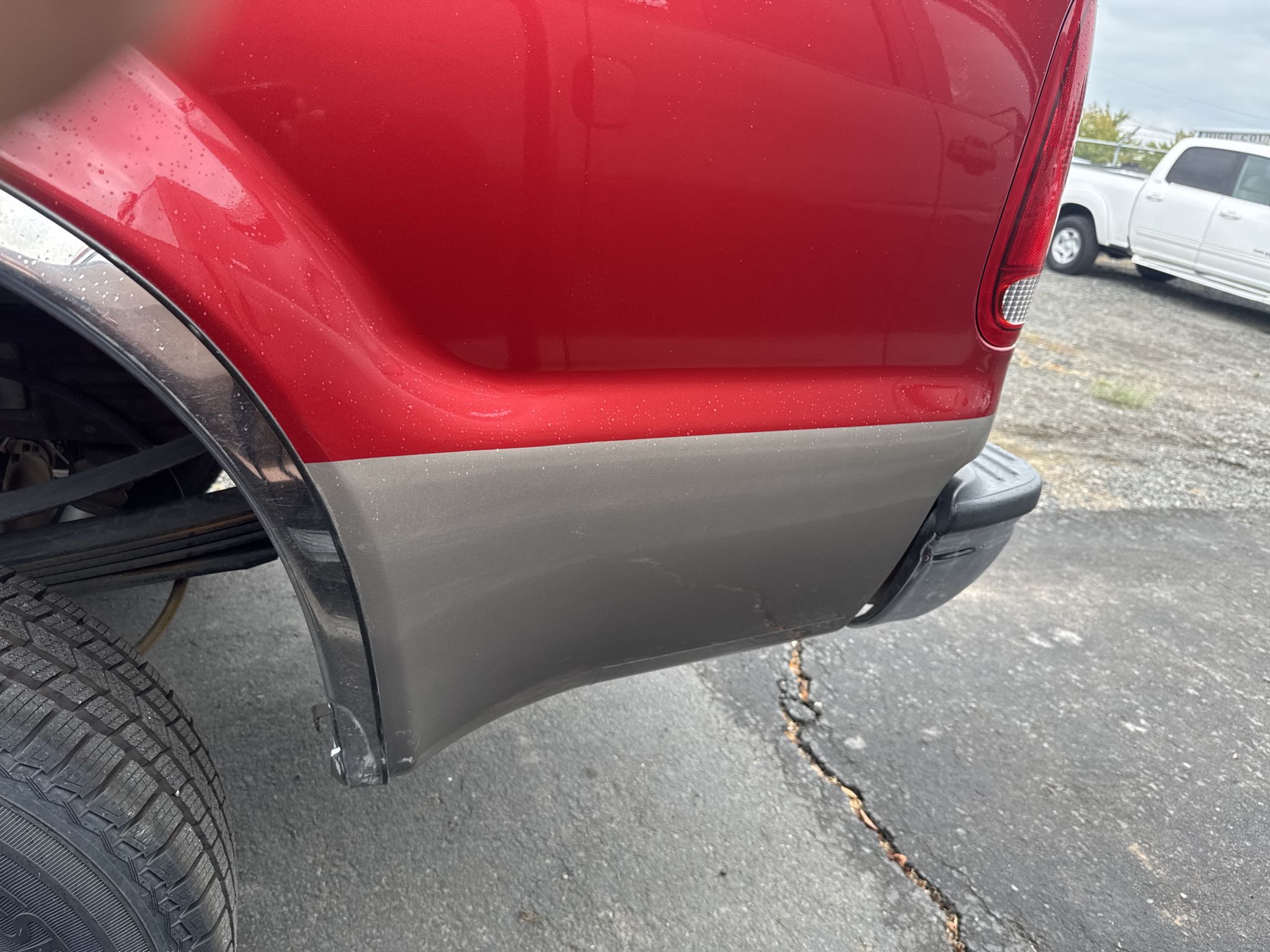 red pickup truck with flawlessly repaired rear quarter panel after collision work