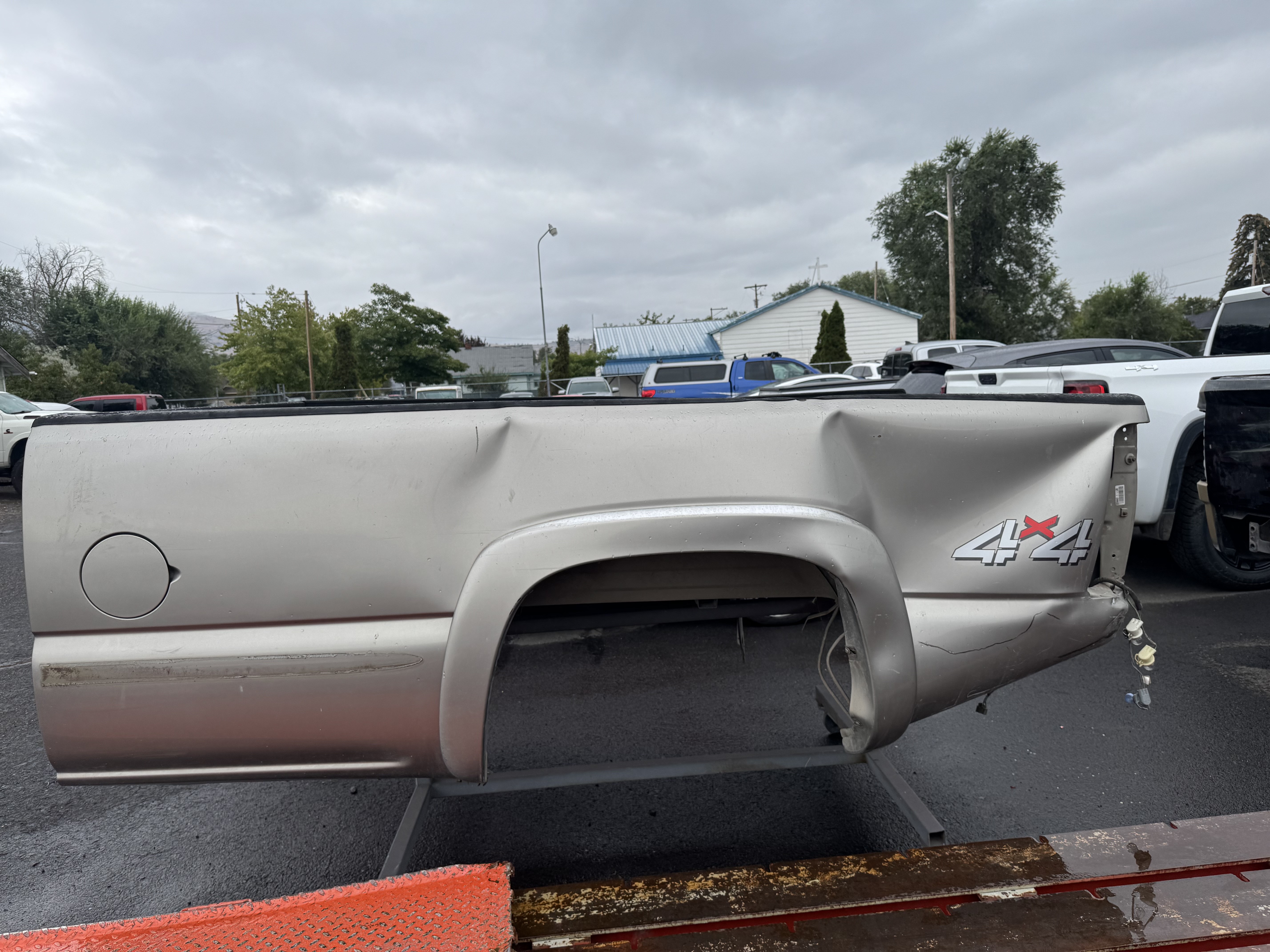 damaged silver truck bed panel section before repair and installation